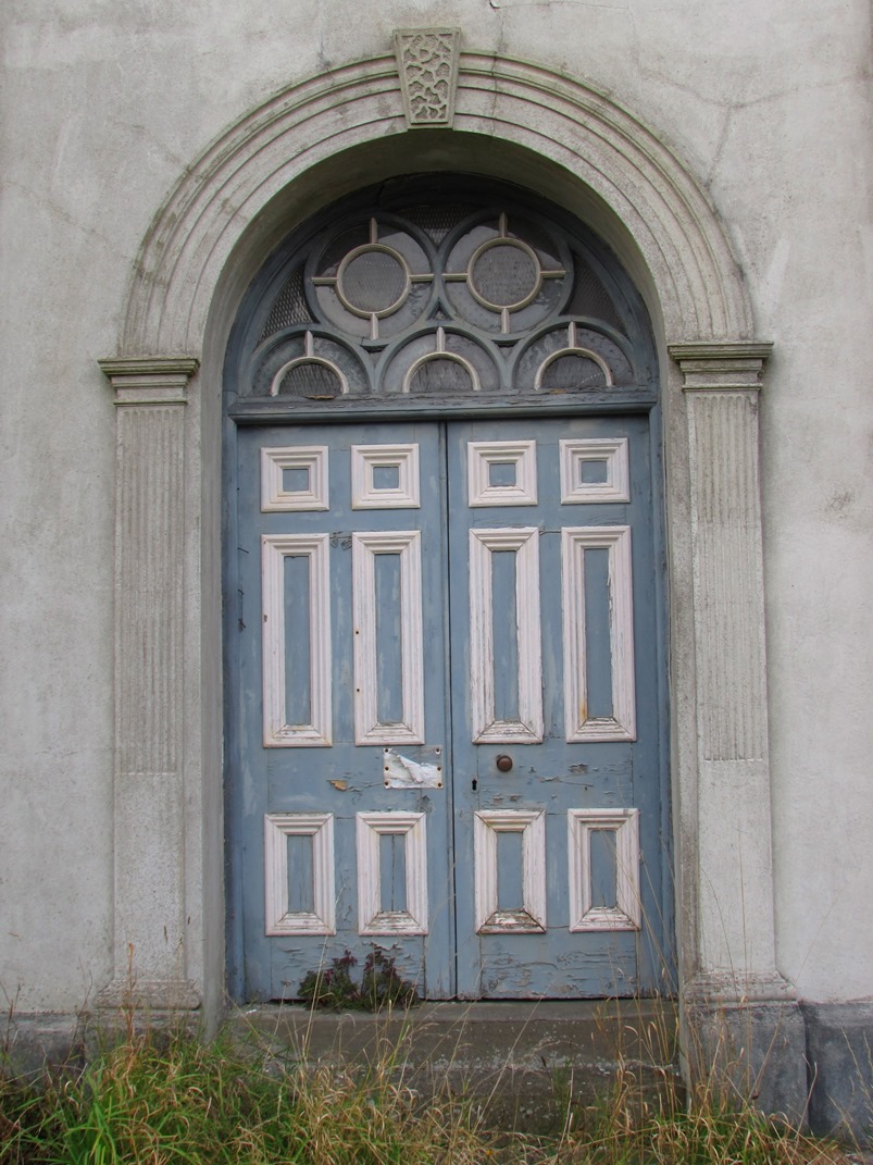 Doorway with pilasters, moulded arch and rusticated keystone.