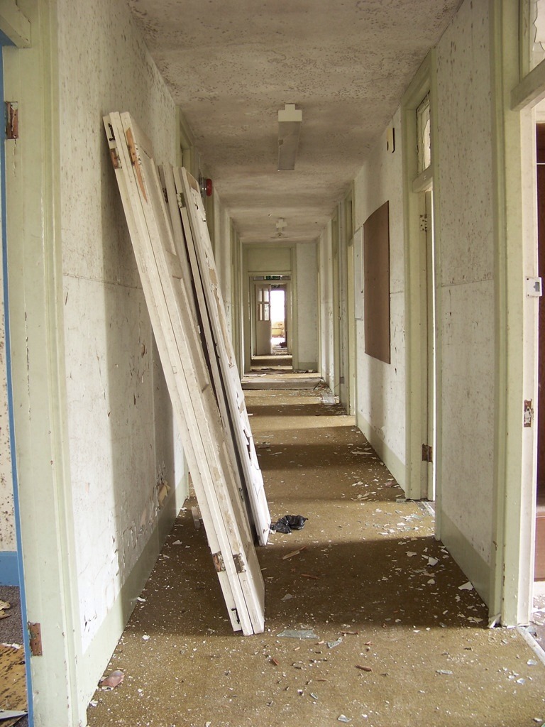 A corridor of bedrooms, each with sink, mirror and built-in wardrobe