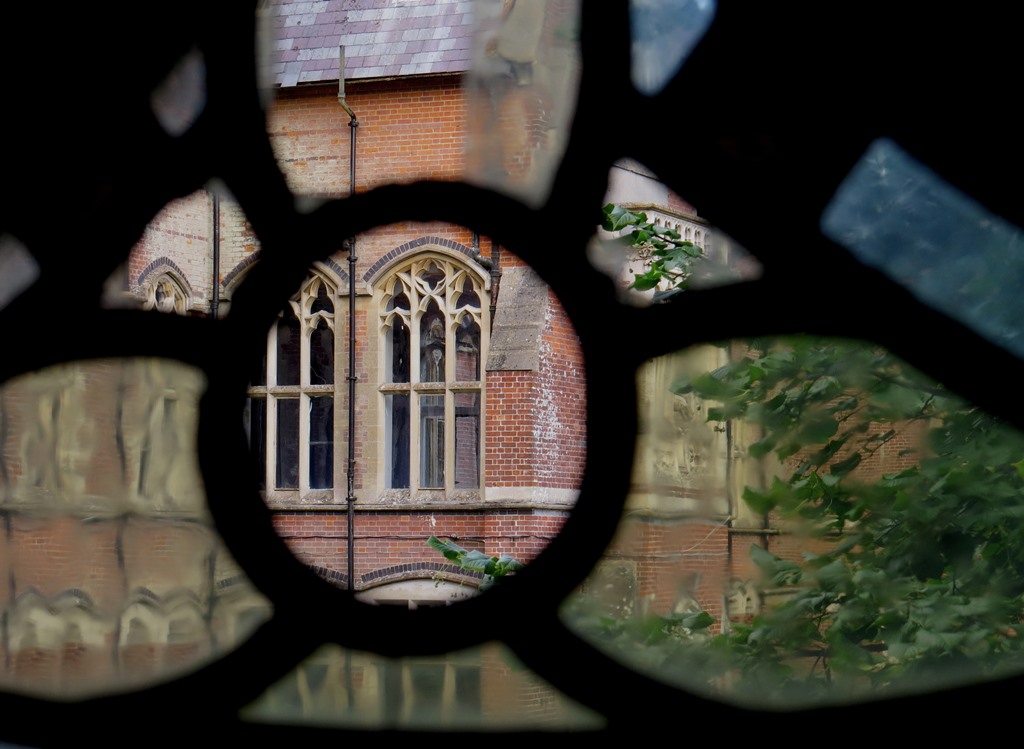 A glimpse of the main buildings caught through the broken vestry window