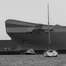 The harbour is dominated by the massive bulk of HMS Queen Elizabeth, which is being fitted out across the water at HMNB